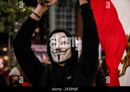 Toronto, Kanada. 24. September 2022. Ein Mann, der eine Guy Fawkes-Maske trägt, schwenkt während der Demonstration eine iranische Flagge über seinen Kopf. Hunderte versammelten sich, um Mahsa Amini zu ehren und gegen die iranische Regierung in Toronto, Kanada, zu protestieren. Kredit: SOPA Images Limited/Alamy Live Nachrichten Stockfoto