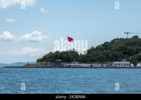 Türkische Flagge und Häuser am Meer in Istanbul, wunderschöne Landschaftsaufnahmen mit blauem Meer, Foto vom Bosporus, offener Himmel und bewölktes Wetter Stockfoto