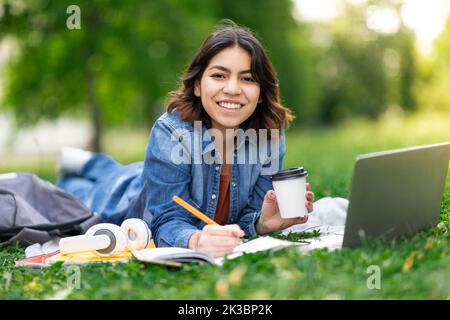 Schöne Junge Arabische Frau Studie Mit Laptop Und Notizpad Im Freien In Park Stockfoto