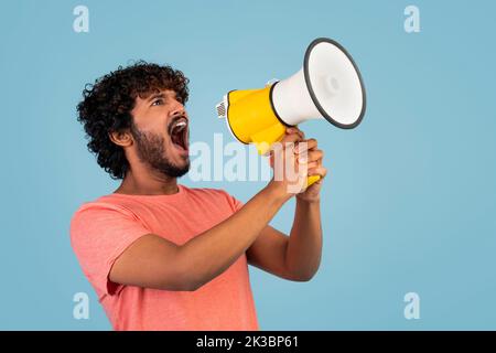 Junger bärtiger inder, der im Megaphon schreit Stockfoto