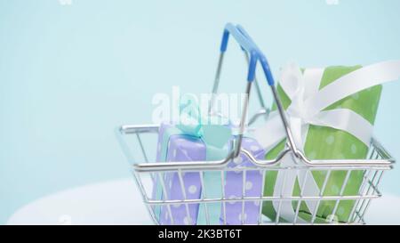 Warenkorb mit eingepackten Geschenkboxen auf blauem Hintergrund, Stockbild Stockfoto