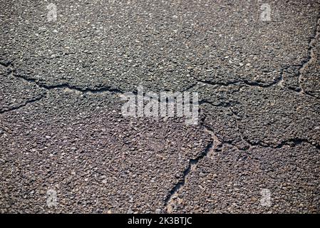 Nahaufnahme Textur von geknacktem Asphalt von den heißen Temperaturen Stockfoto