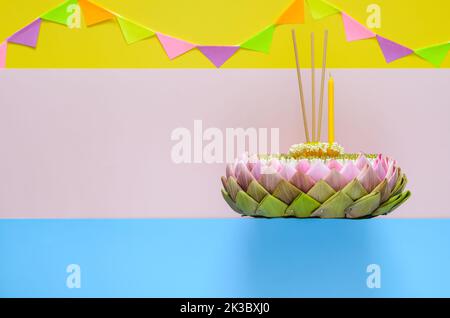 Selektiver Fokus auf Lotuspollen auf dem rosa Lotusblütenblatt krathong mit Kronenblume, Räucherstäbchen und Kerze für das Thailand Loy Krathong Festival auf Stockfoto