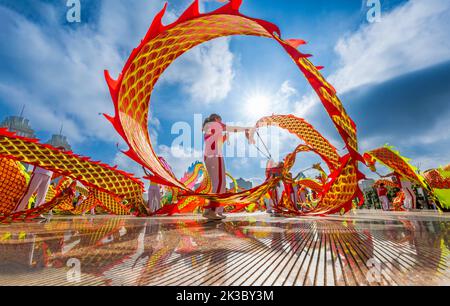 CHONGQING, CHINA - 26. SEPTEMBER 2022 - Menschen tanzen auf einem Platz zur aufgehenden Sonne Banddrachen für Fitness in Chongqing, China, 26. September 2022. Stockfoto