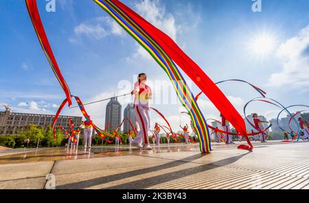 CHONGQING, CHINA - 26. SEPTEMBER 2022 - Menschen tanzen auf einem Platz zur aufgehenden Sonne Banddrachen für Fitness in Chongqing, China, 26. September 2022. Stockfoto