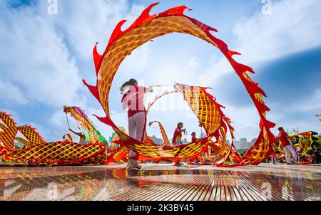 CHONGQING, CHINA - 26. SEPTEMBER 2022 - Menschen tanzen auf einem Platz zur aufgehenden Sonne Banddrachen für Fitness in Chongqing, China, 26. September 2022. Stockfoto