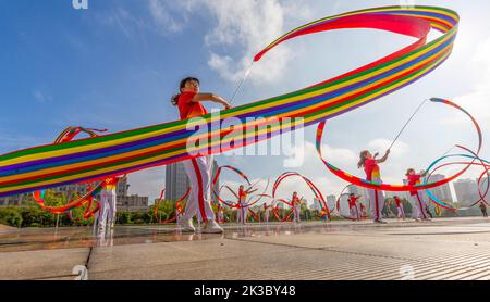 CHONGQING, CHINA - 26. SEPTEMBER 2022 - Menschen tanzen auf einem Platz zur aufgehenden Sonne Banddrachen für Fitness in Chongqing, China, 26. September 2022. Stockfoto