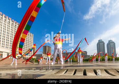 CHONGQING, CHINA - 26. SEPTEMBER 2022 - Menschen tanzen auf einem Platz zur aufgehenden Sonne Banddrachen für Fitness in Chongqing, China, 26. September 2022. Stockfoto