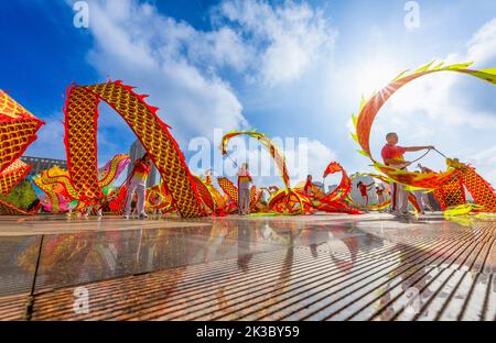 CHONGQING, CHINA - 26. SEPTEMBER 2022 - Menschen tanzen auf einem Platz zur aufgehenden Sonne Banddrachen für Fitness in Chongqing, China, 26. September 2022. Stockfoto