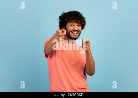 Positiver hindu-Typ, der auf die Kamera zeigt und lächelt Stockfoto