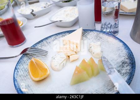 Türkischer Raki-Tisch mit Melone-Zitrone-Weißkäse und Vorspeise, Rübensaft mit rakı, traditioneller türkischer Alkohol, bekannt als Rakı, Speisen auf dem Teller Stockfoto