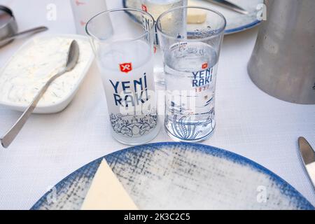 Türkische Yeni Raki Gläser mit Wasser auf dem Tisch mit Vorspeise, traditioneller türkischer Alkohol, bekannt als Rakı, Trinkkonzept, Yeni Rakı Glas Stockfoto