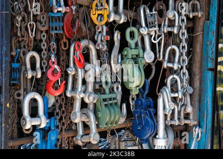 Bunte rostige und neue Marine-Arten von Ausrüstung, hängende rostigen Ketten, roten Haken, Meeres-und Schiffsausrüstung, Meer-und Marine-Markt Idee Stockfoto