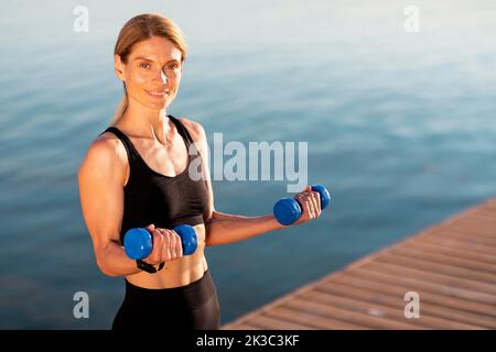 Lächelnd Mittelaltersathletin Training Mit Hanteln Im Freien Stockfoto