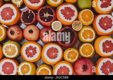 Schneiden Sie Granatapfel Orange Grapefruit Zitrone in Marktstand, Lebensmittel Tapete und Hintergrund, gesundes Leben und vegetarische Idee Stockfoto