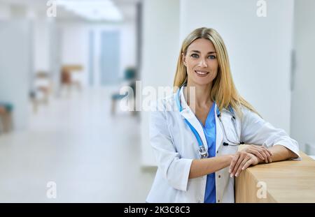 Schöne Hausärztin mit Stethoskop in der Klinik stehend, Porträt. Gesundheitsfachkraft Stockfoto