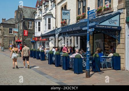 Menschen Touristen Besucher sitzen Abendessen außerhalb Café Restaurant im Stadtzentrum im Sommer Main Street Keswick Cumbria England Großbritannien GB Stockfoto