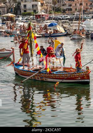 Das jährliche Fest der 'U Pisci a Mari' im sizilianischen Dorf Aci Trezza, in der Nähe von Catania. Dies findet um das Fest der Geburt des hl. Johannes des Täufers Ende Juni statt. Es handelt sich um eine traditionelle Fischereiexpedition für Schwertfisch, die früher in der Straße von Messina stattgefunden hat. Die Rolle des Schwertfisches wird von einem Schwimmer gespielt, der wiederholt von den Fischern gefangen wird, blutig aufgeschnitten wird, dann aber irgendwie entkommen kann. Schließlich schafft es der „Schwertfisch“, das Boot umzustürzen. Stockfoto