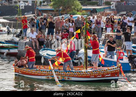 Das jährliche Fest der 'U Pisci a Mari' im sizilianischen Dorf Aci Trezza, in der Nähe von Catania. Dies findet um das Fest der Geburt des hl. Johannes des Täufers Ende Juni statt. Es handelt sich um eine traditionelle Fischereiexpedition für Schwertfisch, die früher in der Straße von Messina stattgefunden hat. Die Rolle des Schwertfisches wird von einem Schwimmer gespielt, der wiederholt von den Fischern gefangen wird, blutig aufgeschnitten wird, dann aber irgendwie entkommen kann. Schließlich schafft es der „Schwertfisch“, das Boot umzustürzen. Stockfoto