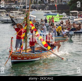 Das jährliche Fest der 'U Pisci a Mari' im sizilianischen Dorf Aci Trezza, in der Nähe von Catania. Dies findet um das Fest der Geburt des hl. Johannes des Täufers Ende Juni statt. Es handelt sich um eine traditionelle Fischereiexpedition für Schwertfisch, die früher in der Straße von Messina stattgefunden hat. Die Rolle des Schwertfisches wird von einem Schwimmer gespielt, der wiederholt von den Fischern gefangen wird, blutig aufgeschnitten wird, dann aber irgendwie entkommen kann. Schließlich schafft es der „Schwertfisch“, das Boot umzustürzen. Stockfoto