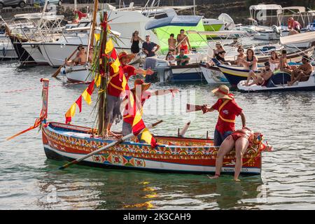 Das jährliche Fest der 'U Pisci a Mari' im sizilianischen Dorf Aci Trezza, in der Nähe von Catania. Dies findet um das Fest der Geburt des hl. Johannes des Täufers Ende Juni statt. Es handelt sich um eine traditionelle Fischereiexpedition für Schwertfisch, die früher in der Straße von Messina stattgefunden hat. Die Rolle des Schwertfisches wird von einem Schwimmer gespielt, der wiederholt von den Fischern gefangen wird, blutig aufgeschnitten wird, dann aber irgendwie entkommen kann. Schließlich schafft es der „Schwertfisch“, das Boot umzustürzen. Stockfoto