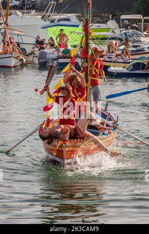 Das jährliche Fest der 'U Pisci a Mari' im sizilianischen Dorf Aci Trezza, in der Nähe von Catania. Dies findet um das Fest der Geburt des hl. Johannes des Täufers Ende Juni statt. Es handelt sich um eine traditionelle Fischereiexpedition für Schwertfisch, die früher in der Straße von Messina stattgefunden hat. Die Rolle des Schwertfisches wird von einem Schwimmer gespielt, der wiederholt von den Fischern gefangen wird, blutig aufgeschnitten wird, dann aber irgendwie entkommen kann. Schließlich schafft es der „Schwertfisch“, das Boot umzustürzen. Stockfoto