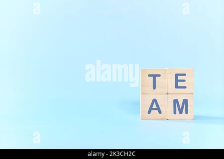 Teamwork und Teambuilding-Geschäftskonzept. Hand zusammen Holzblöcke Holz Puzzle-Stücke in blauem Hintergrund. Stockfoto