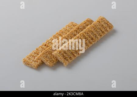 Sesamsamen-Bonbons, in einer Holzschale. Sesam spröde oder Crunch, eine Konfektion aus Sesamsamen und Honig, der in flache Riegel gepresst wird, ein beliebter Snack Stockfoto