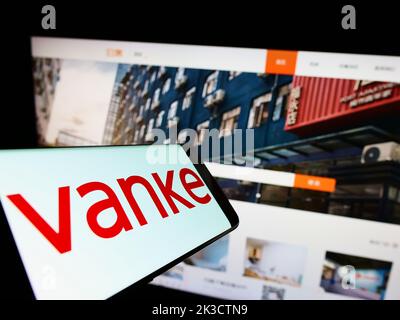 Handy mit Logo der chinesischen Immobiliengesellschaft Vanke Co. Ltd. Auf dem Bildschirm vor der Business-Website. Fokus rechts neben dem Telefondisplay. Stockfoto