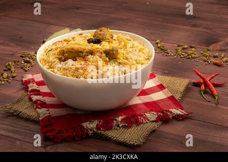 Chicken biriyani, kerala Stil Huhn dhum biriyani aus Jeera Reis und Gewürze in irdenen Geschirr mit Raitha und Zitroneneinlage als Seite d angeordnet gemacht Stockfoto