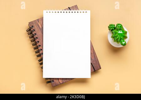 Notizblock öffnen, Heimpflanze, goldener Stift auf beigem Hintergrund Spiralnotizbuch auf Tisch Geschäft, Planung, Bildung, Morgenleben Arbeiten von zu Hause aus Konzept Draufsicht Flat Lay Mock Up. Stockfoto