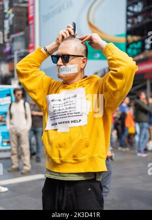 New York City, USA. 25. September 2022. Ein Mann auf dem Times Square in New York City, NY, rasierte sich seinen Kopf in einer Hommage an Mahsa Amini, die in Polizeigewahrsam starb, nachdem sie von der Moralpolizei verhaftet wurde, weil sie ihren Hijab im Iran in Teheran am 25. September 2022 nicht richtig trug. (Foto von Steve Sanchez/Sipa USA) Quelle: SIPA USA/Alamy Live News Stockfoto