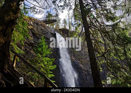 Blick von unten auf die Plodda Falls und die Aussichtsplattform, die von einem üppigen Wald umgeben ist, einem beliebten Wasserfall in der Nähe des Dorfes Tomich in den Highlands Stockfoto