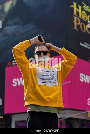 Ein Mann auf dem Times Square rasiert sich den Kopf in einer Hommage an Mahsa Amini, die in Polizeigewahrsam starb, nachdem sie verhaftet wurde, weil sie ihren Hijab im Iran in Teheran nicht richtig trug. (Foto von Steve Sanchez/Pacific Press) Stockfoto