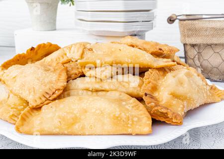 Gefüllte Empanadas mit Fleisch und Käse auf einem weißen Teller serviert. Stockfoto