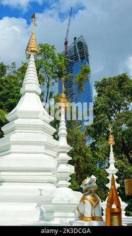 Eine vertikale Aufnahme des weißen buddhistischen Tempelkomplexes mit kunstvoll verzierten, goldenen Schreinen an einem sonnigen Tag Stockfoto