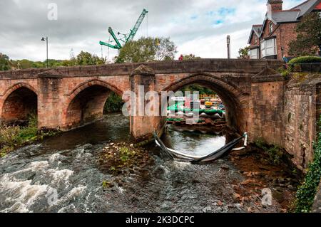 Hochwasserschutzreparaturen mit einem riesigen Kran am Ufer des Flusses Derwent an der Matlock Bridge, Matlock, Derbyshire, Großbritannien Stockfoto