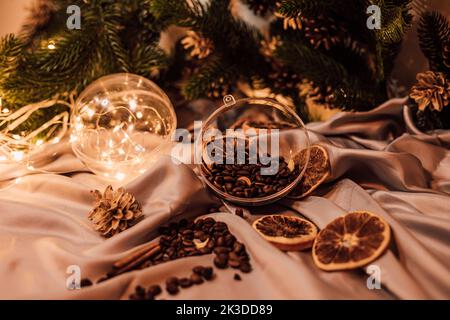 Kaffeebohnen auf braunem Hintergrund, Girlanden und Nadelzweigen. Neujahr Stockfoto