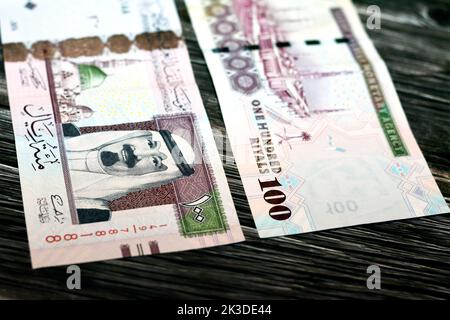 Eine Nahaufnahme der Saudi-Arabien 100 SAR einhundert riyale Bargeld-Banknoten auf einer hölzernen Oberfläche Stockfoto