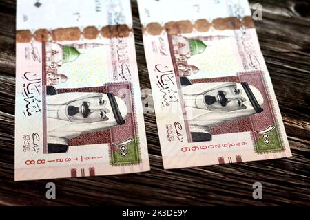 Eine Nahaufnahme der Saudi-Arabien 100 SAR einhundert riyale Bargeld-Banknoten auf einer hölzernen Oberfläche Stockfoto