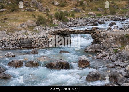 Landschaftlich reizvolle Aussicht auf die traditionelle Holzbrücke am Fluss Shing in sieben Seen, Marguzor, Fann Mountains, Sughd Region, Tadschikistan Stockfoto