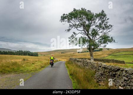 Seniorradfahrer auf einem E-Bike, der die Fahrspuren um Ravenstonedale in den Howgills Cumbrian Hills, England, Großbritannien, erkundet Stockfoto