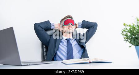 Müde Manager entspannen in Schlafmaske am Arbeitsplatz Stockfoto
