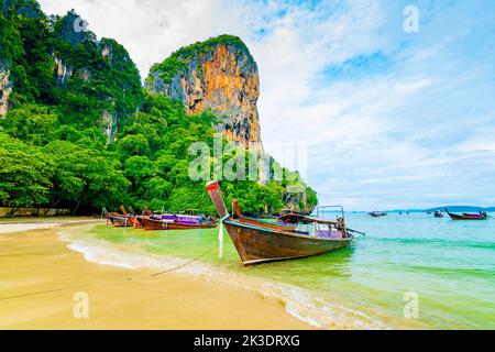 Der berühmte Railay Strand in Krabi, Thailand. Langschwanzboote werden für Passagiere in der Nähe von Kalksteinfelsen vorbereitet. Tropisches Paradies, berühmter touristischer Desti Stockfoto