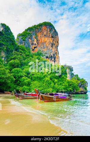 Der berühmte Railay Strand in Krabi, Thailand. Langschwanzboote werden für Passagiere in der Nähe von Kalksteinfelsen vorbereitet. Tropisches Paradies, berühmter touristischer Desti Stockfoto