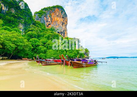 Der berühmte Railay Strand in Krabi, Thailand. Langschwanzboote werden für Passagiere in der Nähe von Kalksteinfelsen vorbereitet. Tropisches Paradies, berühmter touristischer Desti Stockfoto