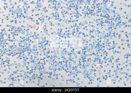 Konfetti aus silbernem Kristall auf blauem pastellfarbenem Hintergrund. Leuchtende festliche Textur. Stockfoto