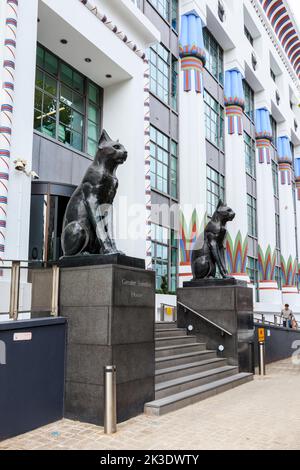 Schwarze Katzen auf Wache im Greater London House, einem großen Art déco-Gebäude in Camden, London, Großbritannien. Es ist ein Beispiel für die ägyptische Wiedergeburt des frühen 20.. Jahrhunderts Stockfoto