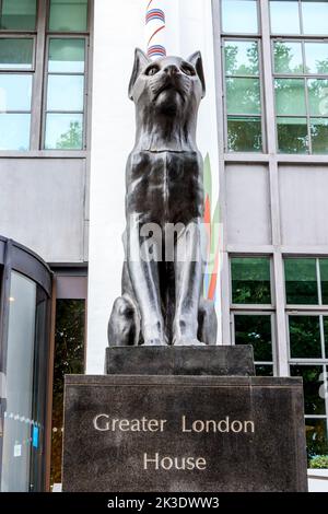 Schwarze Katzen auf Wache im Greater London House, einem großen Art déco-Gebäude in Camden, London, Großbritannien. Es ist ein Beispiel für die ägyptische Wiedergeburt des frühen 20.. Jahrhunderts Stockfoto