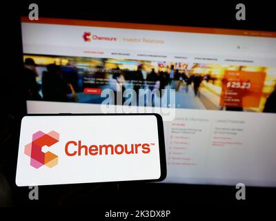 Person, die das Smartphone mit dem Logo des US-Chemieherstellers The Chemours Company auf dem Bildschirm vor der Website hält. Konzentrieren Sie sich auf die Telefonanzeige. Stockfoto